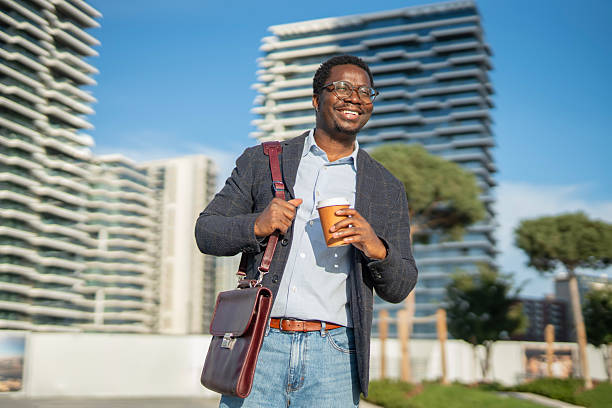 istock Happy young black man commuting, drinking coffee in city 2243578015