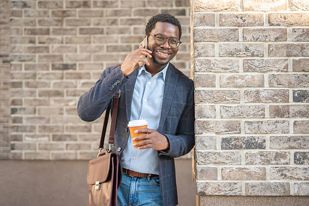 istock Smiling business man talking on smartphone drinking coffee 2243578049