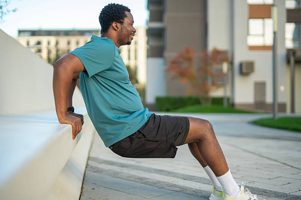 istock Young adult man doing dips exercise outdoors in urban environment 2243578113