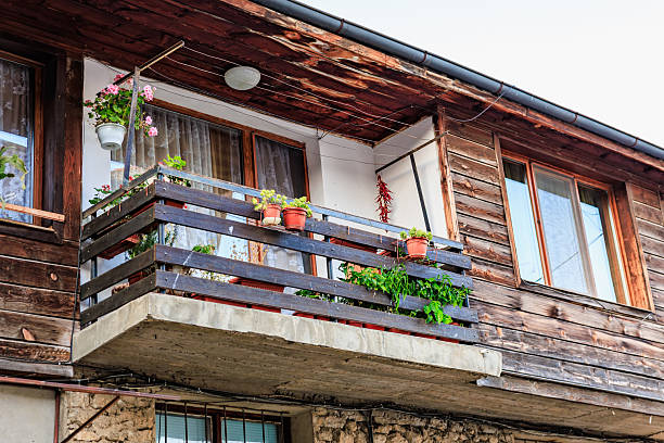 Pink hydrangea flowers on pots decorating a balcony in wooden mountain lodge Cantabria Spain