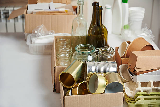 istock Sorting garbage for recycling. Cardboard boxes with various garbage, plastic and tin cans, glass bottles on table. Waste sorting, waste recycle. Garbage separation concept. 2243579278