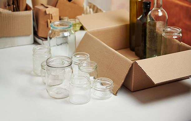 istock Sorting garbage for recycling. Separate glass cans into cardboard box at home.. Waste sorting, waste recycle. Garbage separation concept. 2243579365