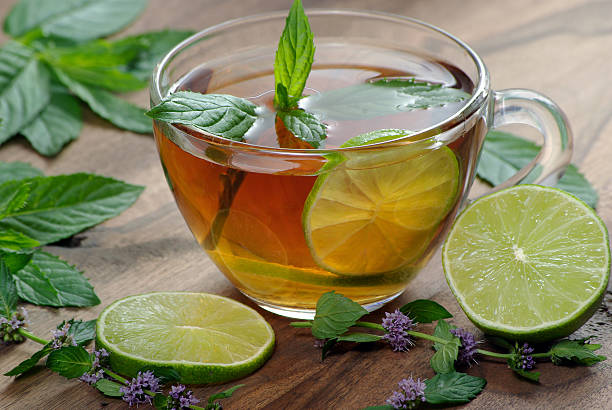 istock cup of mint tea and lime on a wooden table. herbal tea 2243579920