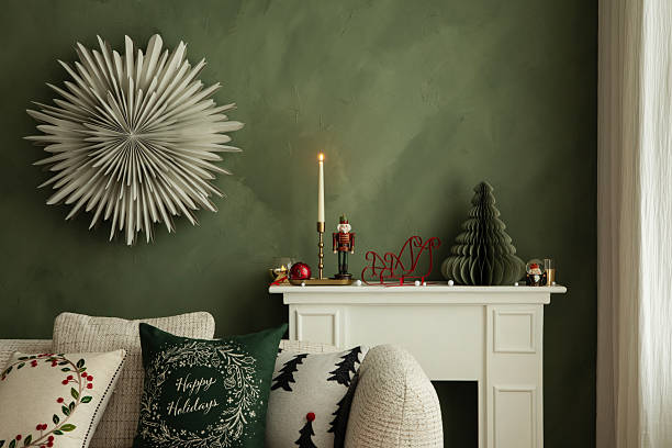 Stylish holiday interior with candles, nutcracker, and modern Christmas decorations on a white mantel against a green wall.