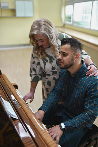 istock Male And Female Pianists Collaborating Closely While Playing Piano Duet With Concentration 2243583379