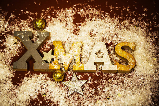 Xmas letters in snow with golden decorations
