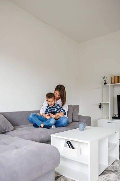 istock Mother and son using smart phone at home 2243585836