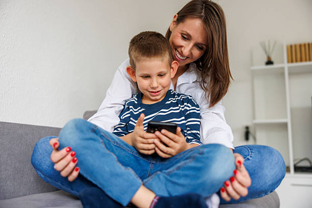 istock Mother and son having fun playing video games using smart phone at home 2243586068