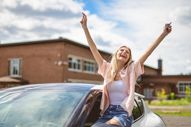 istock Beautiful young girl driver with with her white car 2243588956