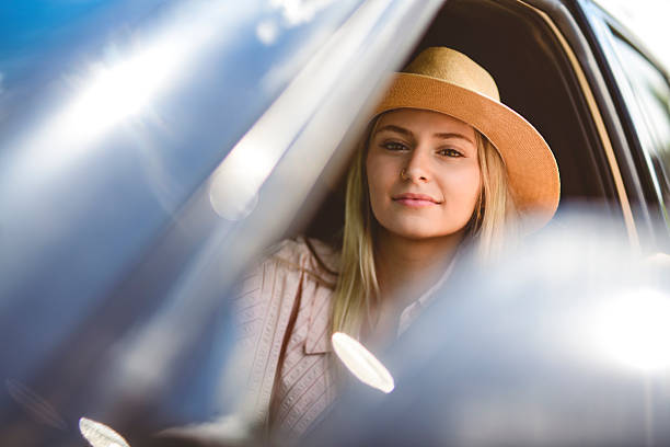 A Beautiful young girl driver with with her white car