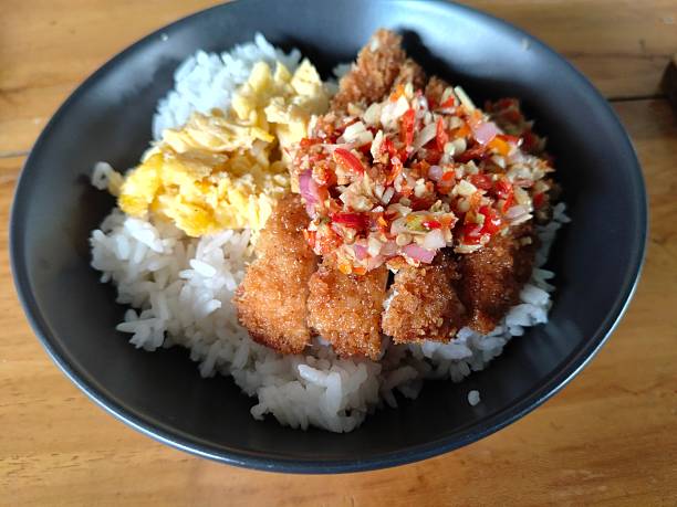 a bowl of rice with chicken katsu with chili