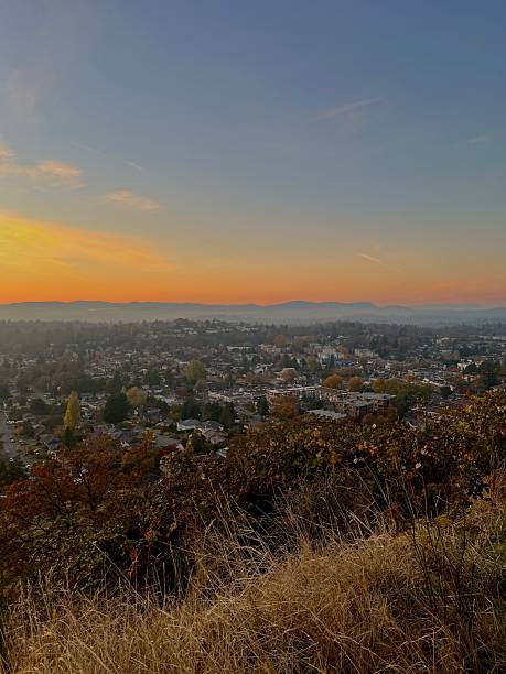 istock City at dusk viewed from hilltop with sunset sky 2243595045