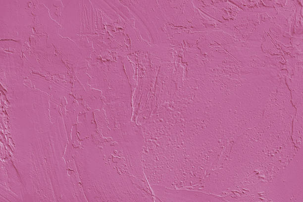 istock Close up pink colored painted plaster wall surface background with rough brushstrokes texture 2243596683
