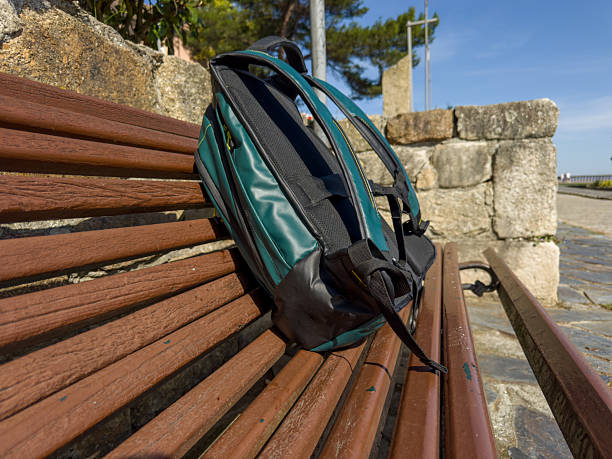 istock Backpack left on wooden bench outdoors 2243597720