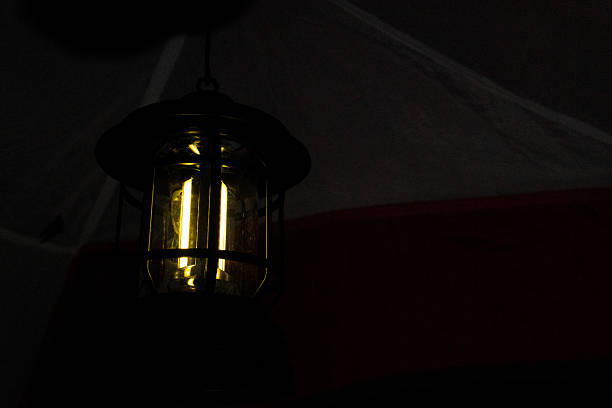 Camping lantern glowing warmly inside a tent, creating a cozy and inviting atmosphere for a night of adventure and relaxation.