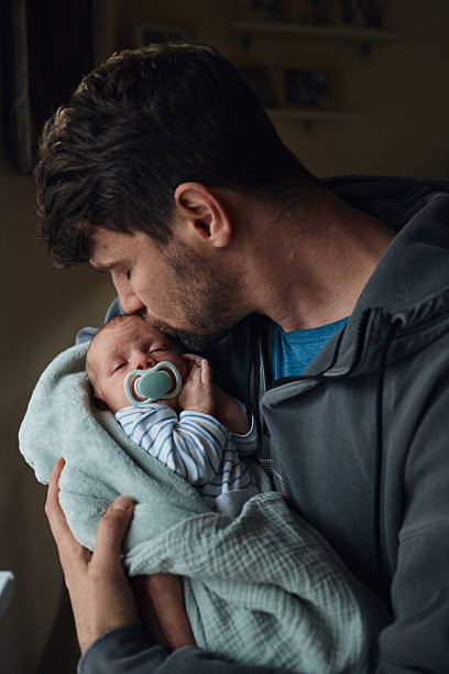 istock Father kissing sleeping newborn baby's forehead 2243599474