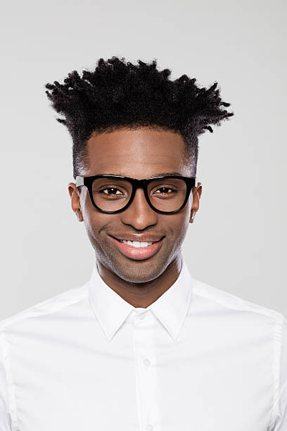 Close up portrait of happy young afro american businessman in nerd eyeglasses on gray background.