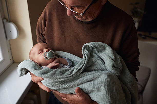 A Grandfather on the sofa with baby at home