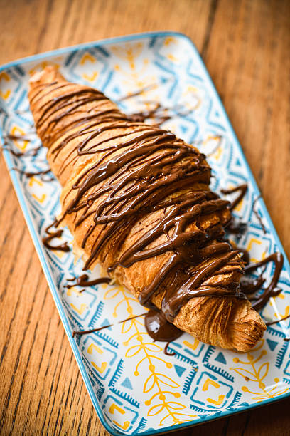 istock Chocolate Drizzled Croissant on Decorative Plate for Breakfast or Bakery Scene 2243602947