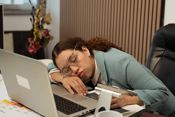 istock Woman sleeping on office desk due to burnout 2243604936