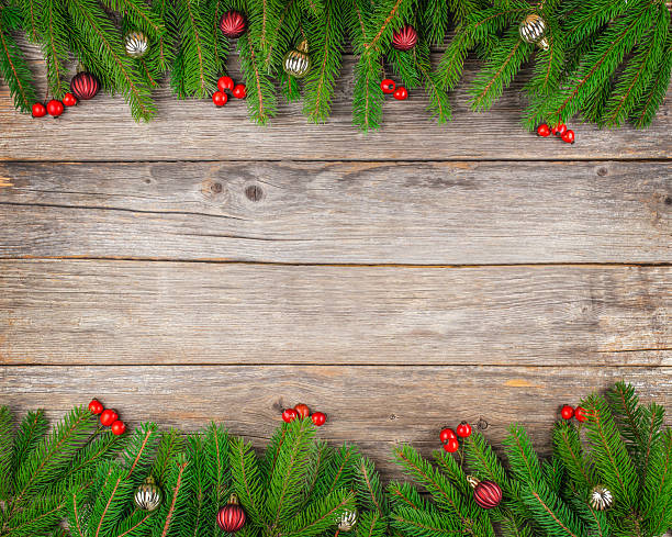 istock Christmas background with fir branches, red berries, and baubles on rustic wooden surface, festive top view composition with copy space for holiday greeting or banner design 2243606890