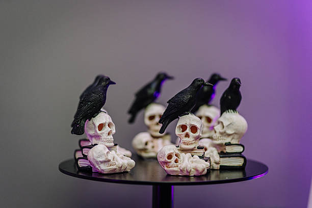 istock Decorative skulls and black crows arranged on a table, creating a spooky Halloween atmosphere with dark tones and eerie ambiance 2243607441