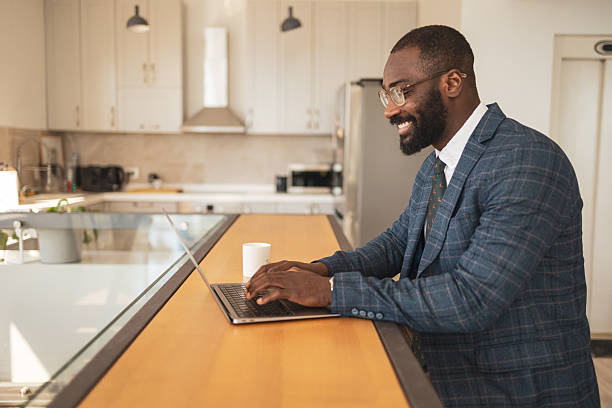 istock Business professional working on laptop in a modern home kitchen setting 2243607495
