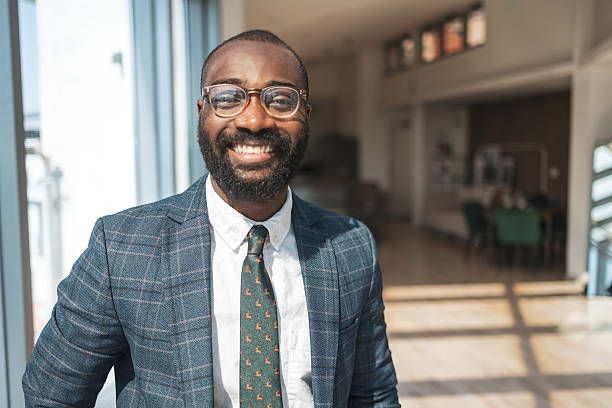 istock Smiling professional standing in a modern sunny office environment 2243607511