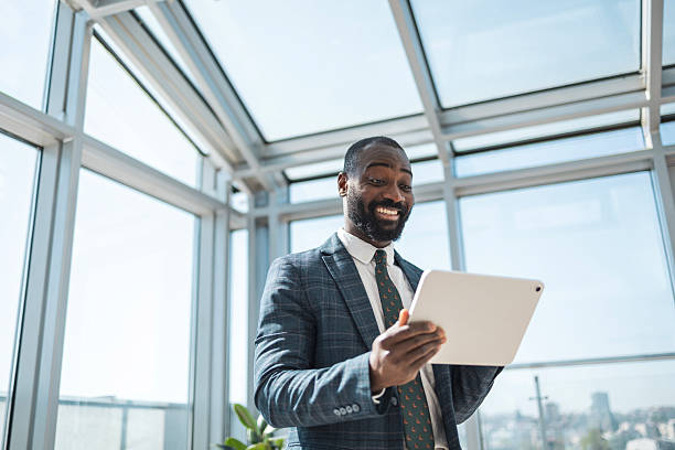 istock Smiling businessman using a tablet in a brightly lit office environment 2243607515