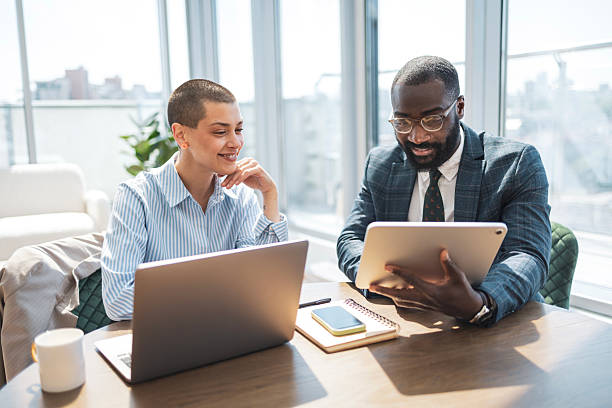 istock Two business professionals collaborate in a modern office setting with natural light 2243607555