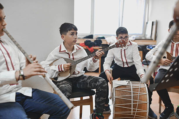 istock Boys Practicing Variety Of Traditional Musical Instruments Together In Classroom Setting 2243607629