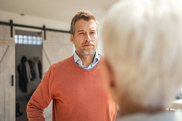 istock Man in a discussion facing another person in a bright interior space 2243607864