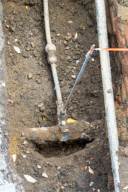 istock Underground water pipe repair work showing connection point and exposed utility lines 2243607869