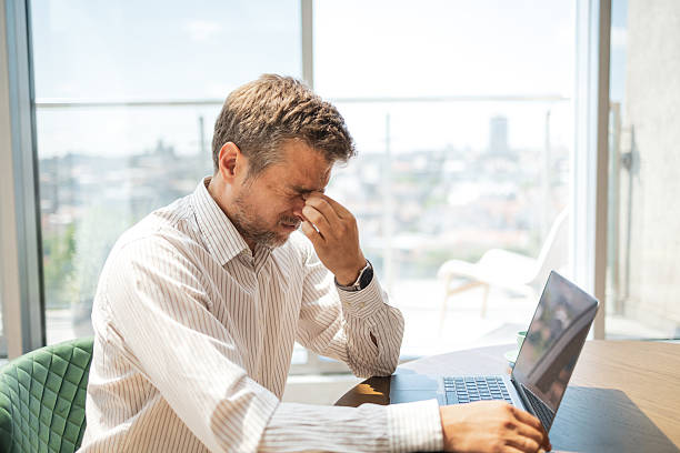 istock Stressed businessman sitting at desk struggling with work pressures 2243607928