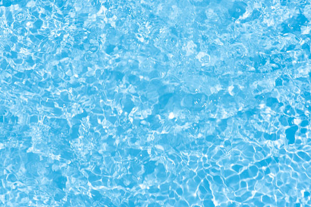istock Blue water with ripples on the surface. Defocus blurred transparent blue colored clear calm water surface texture with splashes and bubbles. Water waves with shining pattern texture background. 2243608584