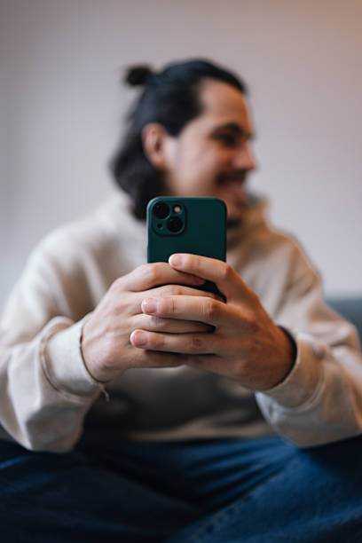 istock Smiling Man Holding Smartphone at Home stock 2243610079