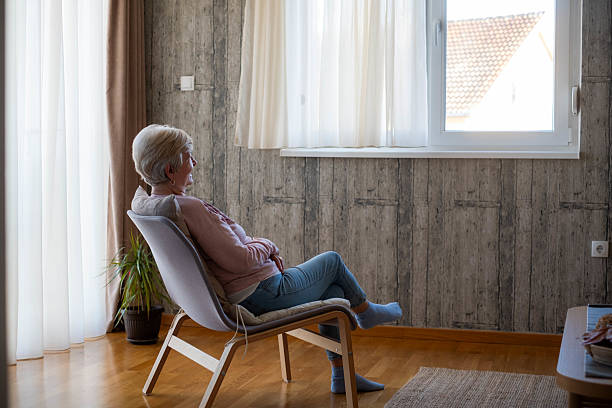 istock Senior woman relaxing at home looking out window 2243610492