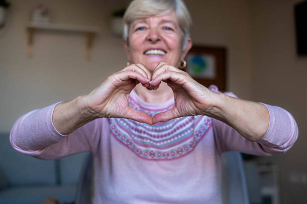 istock Senior woman making heart gesture with hands, smiling 2243611881