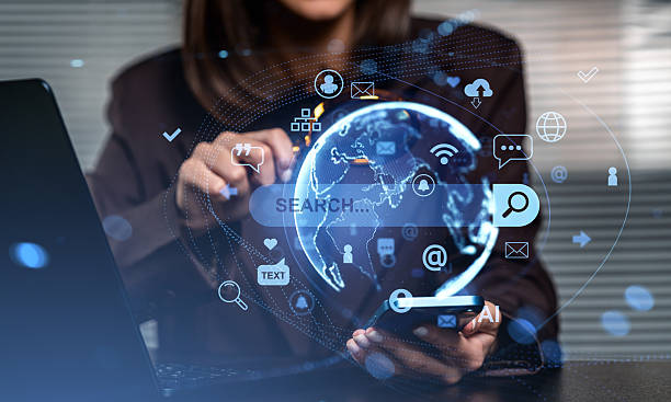 istock Woman using smartphone and laptop with holographic digital globe 2243612347