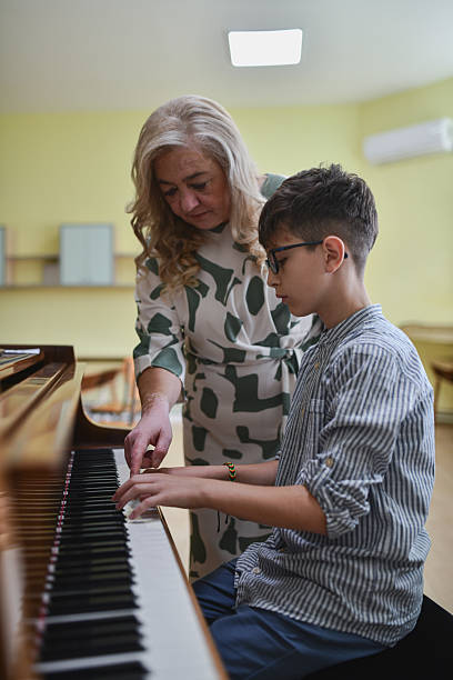istock Teacher And Teen Piano Student Working On Classical Piece During Concentrated Practice Session 2243613872