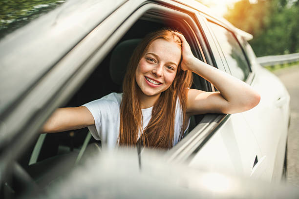 istock Beautiful young girl driver with with her white car 2243615280