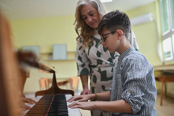 istock Dedicated Music Teacher Observing Young Pianist Perform During Calm And Focused Lesson Time 2243615837