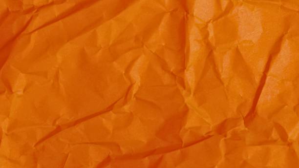 istock Textured orange fabric with deep folds and shadows 2243615981