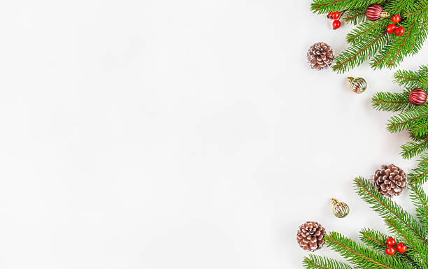 istock Minimalistic Christmas background with fir branches, pine cones, red berries, and ornaments on white surface, festive flat lay composition with copy space for holiday greeting or winter design 2243617342
