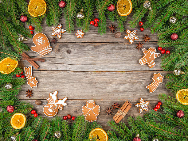istock Christmas composition with gingerbread cookies, fir branches, dried oranges, cinnamon sticks, berries, and festive decorations on rustic wooden background, top view with copy space 2243617346