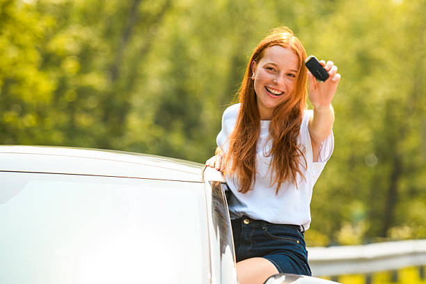 istock Beautiful young girl driver with with her white car 2243618868