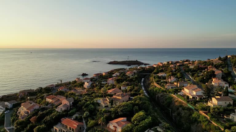 Aerial panoramic view of the Esterel Mountains near Saint Raphael, French Riviera, showing the Mediterranean Sea and luxury villas along the Cote dAzur coastline in the warm sunrise light