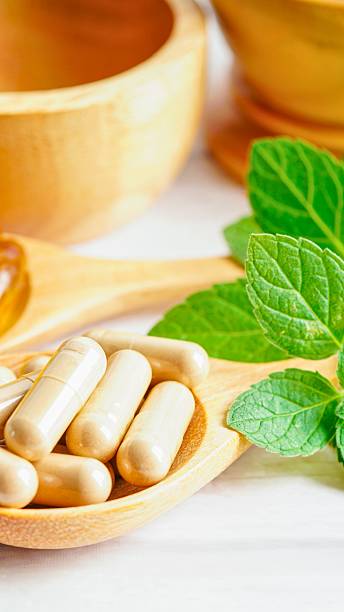 istock Herbal supplements and fresh mint leaves on wooden utensils 2243619309