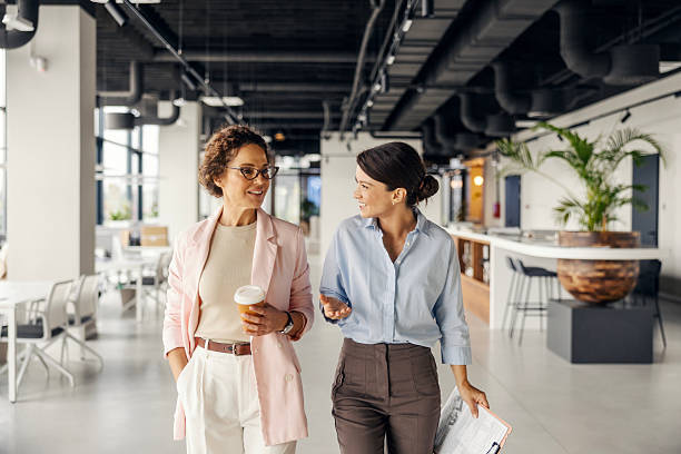 istock Businesswomen walking and talking, collaborating in modern office 2243620004