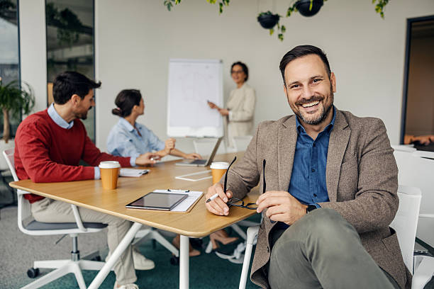 istock Happy businessman smiling during office team meeting 2243620104